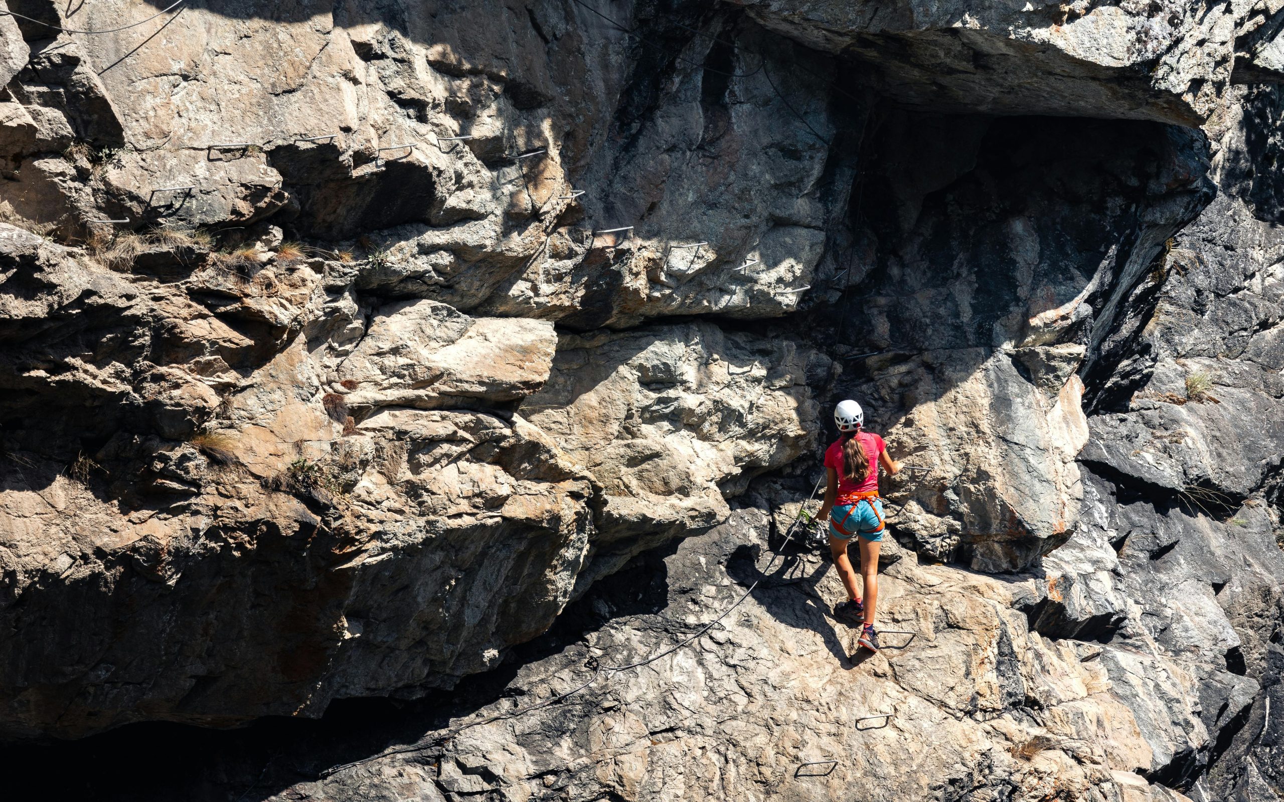 Climber struggling mid-route due to improper gear setup.